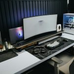A sleek, modern office setup with a gaming PC, curved monitor, and accessories, ideal for tech enthusiasts.