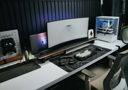 A sleek, modern office setup with a gaming PC, curved monitor, and accessories, ideal for tech enthusiasts.