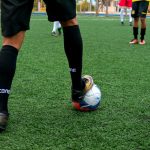 Close-up of a soccer player controlling the ball during a match on a green field.