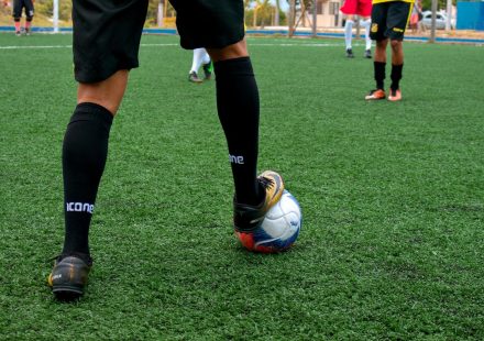 Close-up of a soccer player controlling the ball during a match on a green field.