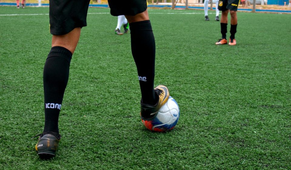 Close-up of a soccer player controlling the ball during a match on a green field.