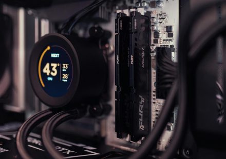 Detailed view of a gaming PC's interior featuring RAM and a digital CPU cooler display.