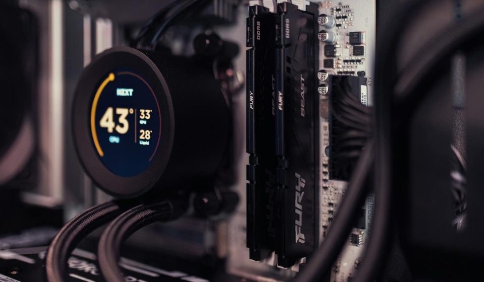 Detailed view of a gaming PC's interior featuring RAM and a digital CPU cooler display.