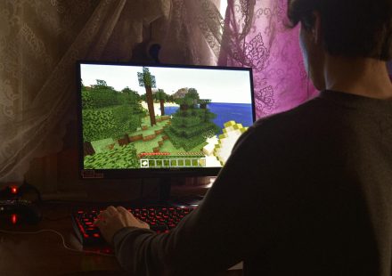 A young man intensely playing a PC video game indoors. Capturing the essence of technology and concentration.