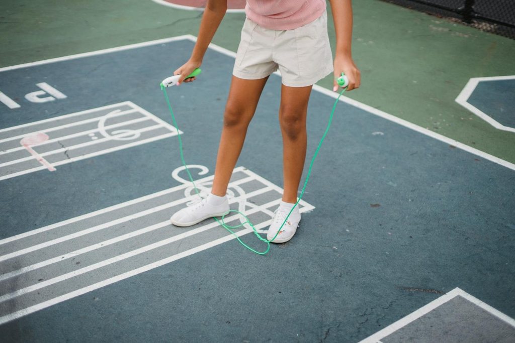 A person jumping rope on a colorful outdoor basketball court. Fitness and fun.