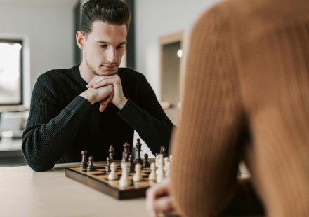 A man intently focuses on his next move during a chess game indoors.