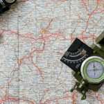 Close-up view of a compass on a detailed map, ideal for travel and navigation concepts.