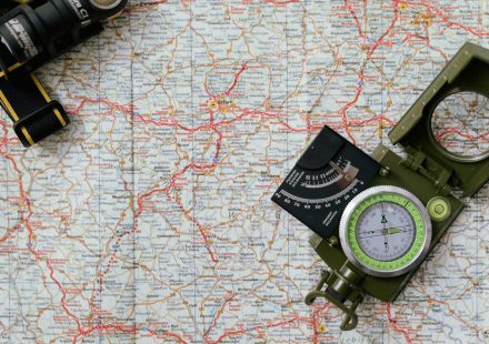Close-up view of a compass on a detailed map, ideal for travel and navigation concepts.