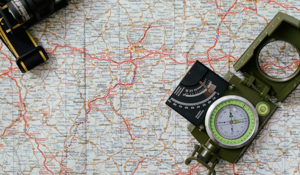 Close-up view of a compass on a detailed map, ideal for travel and navigation concepts.