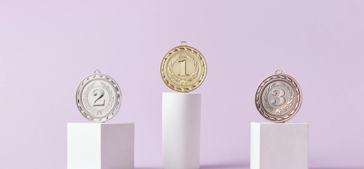 Medals on a podium against a soft pastel background, ideal for awards themes.