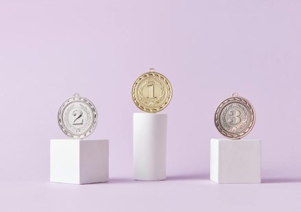 Medals on a podium against a soft pastel background, ideal for awards themes.