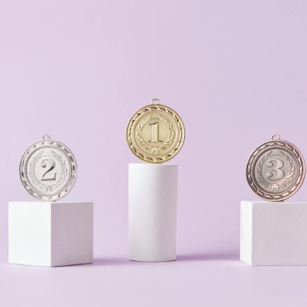 Medals on a podium against a soft pastel background, ideal for awards themes.