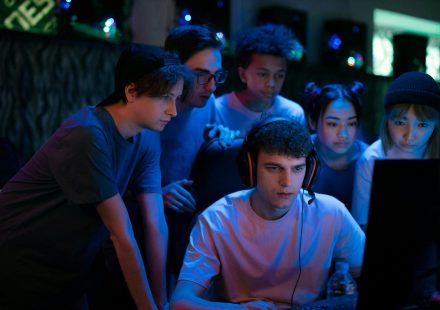 Group of diverse teenagers gaming together indoors, intense and focused.