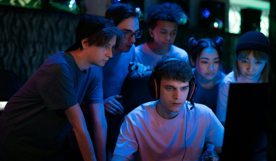 Group of diverse teenagers gaming together indoors, intense and focused.