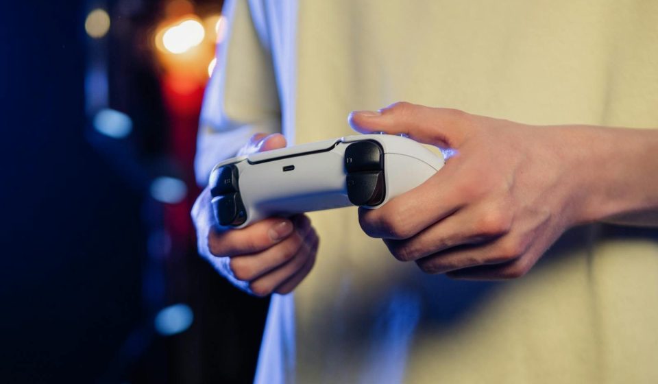 Hands gripping a game controller, displaying focus during an intense gaming session.