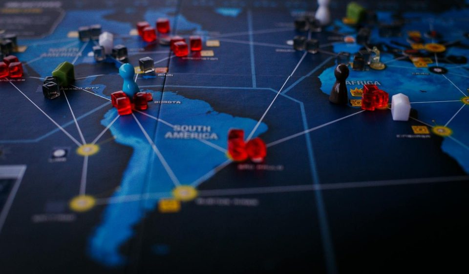 A strategic board game featuring a world map and colorful playing pieces.