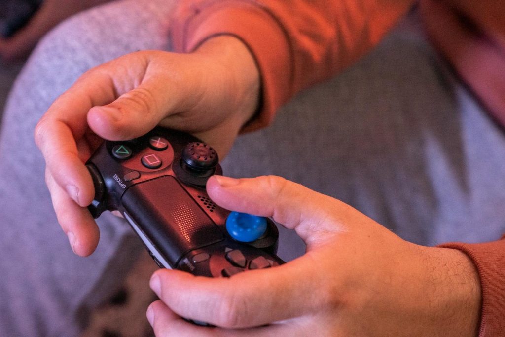 Hands gripping a game controller, showcasing intense gaming focus.