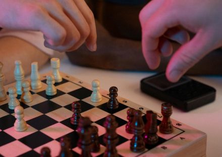 Close-up of hands playing a chess game, capturing strategic moves and intense focus.