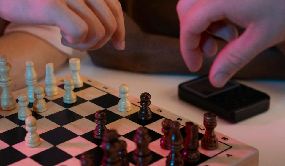 Close-up of hands playing a chess game, capturing strategic moves and intense focus.