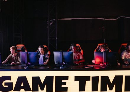 A group of diverse gamers participating in an online eSports tournament indoors.
