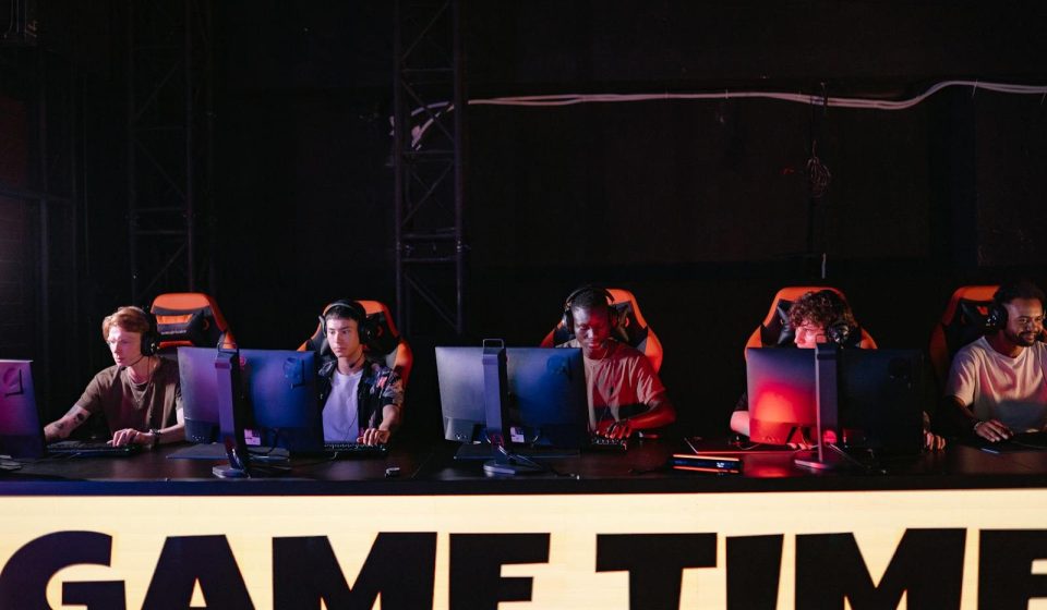 A group of diverse gamers participating in an online eSports tournament indoors.