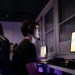 a man sitting in front of a computer with headphones on