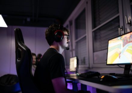 a man sitting in front of a computer with headphones on